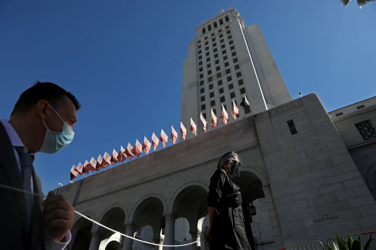 Court interpreter Rosario Blye, right, attends a vigil on the steps of L.A. City Hall
