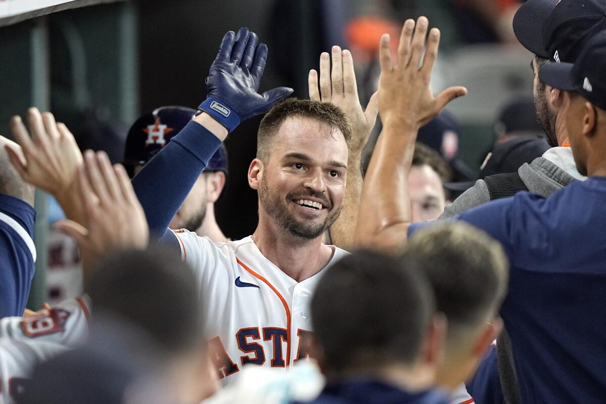 Houston Astros' Trey Mancini celebrates with teammates in the dugout after hitting a two-run home run against the Boston Red Sox during the second inning of a baseball game Wednesday, Aug. 3, 2022, in Houston. (AP Photo/David J. Phillip)