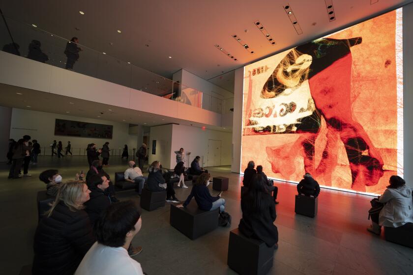 Varios visitantes observan una obra de la exposición "Unsupervised" ("Sin supervisión") del artista Refik Anadol en el Museo de Arte Moderno de Nueva York, el miércoles 11 de enero de 2023. Las obras de la exhibición fueron generadas por IA y pretenden ser una interpretación que invite a la reflexión de la prestigiosa colección del museo neoyorquino. (AP Foto/John Minchillo)