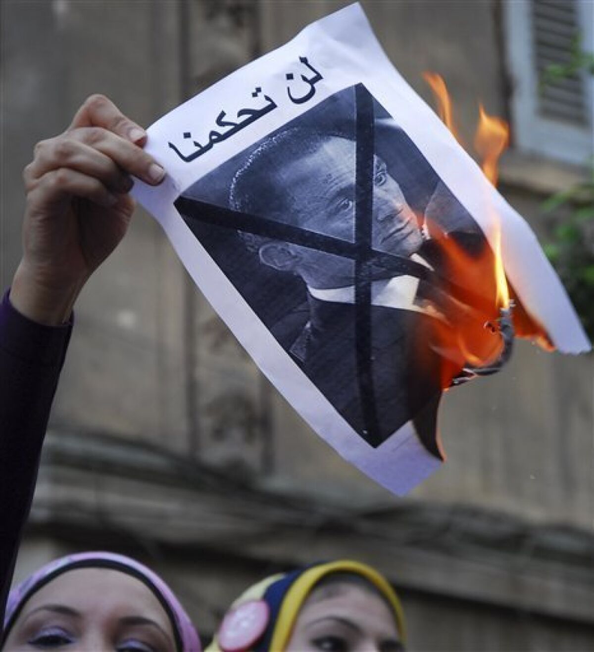 Egyptian activists burn a poster showing Gamal Mubarak, the son of Egyptian President Hosni Mubarak, during a protest in Cairo, Egypt, Tuesday, Sept. 21, 2010. Egyptian police beat and arrested anti-government activists demonstrating outside the downtown presidential palace against a possible father-son succession in the country. (AP Photo)