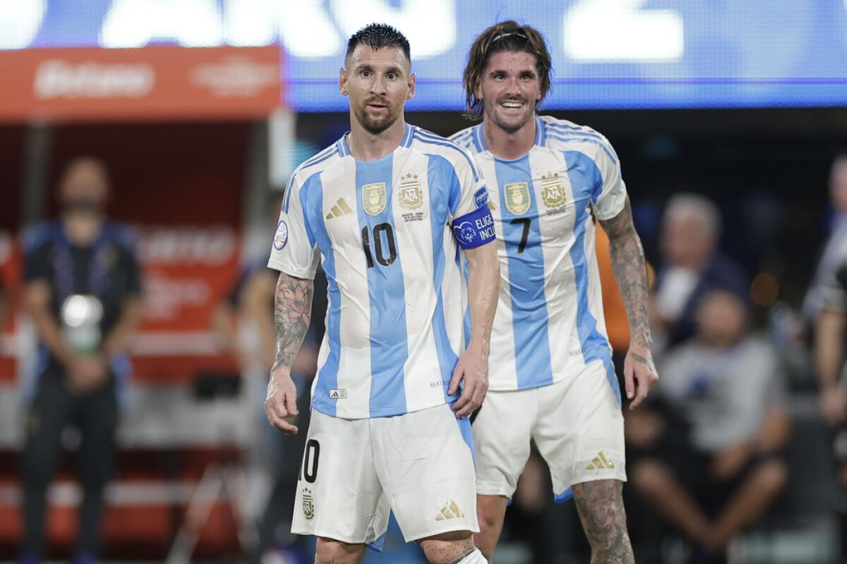 Los argentinos Lionel Messi (izquierda) y Rodrigo De Paul