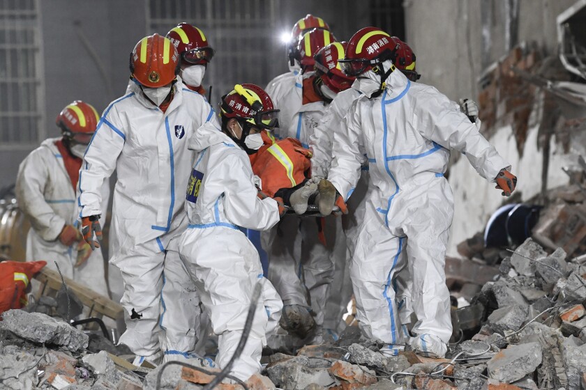 In this photo released by Xinhua News Agency, rescue workers evacuate the 10th survivor pulled alive after being trapped 132 hours from the debris of a self-built residential structure that collapsed in Changsha in central China's Hunan Province on Thursday May 5, 2022. Rescuers in central China have pulled the woman alive from the rubble of a building that partially collapsed almost six days earlier, state media reported Thursday. (Shen Hong/Xinhua via AP)