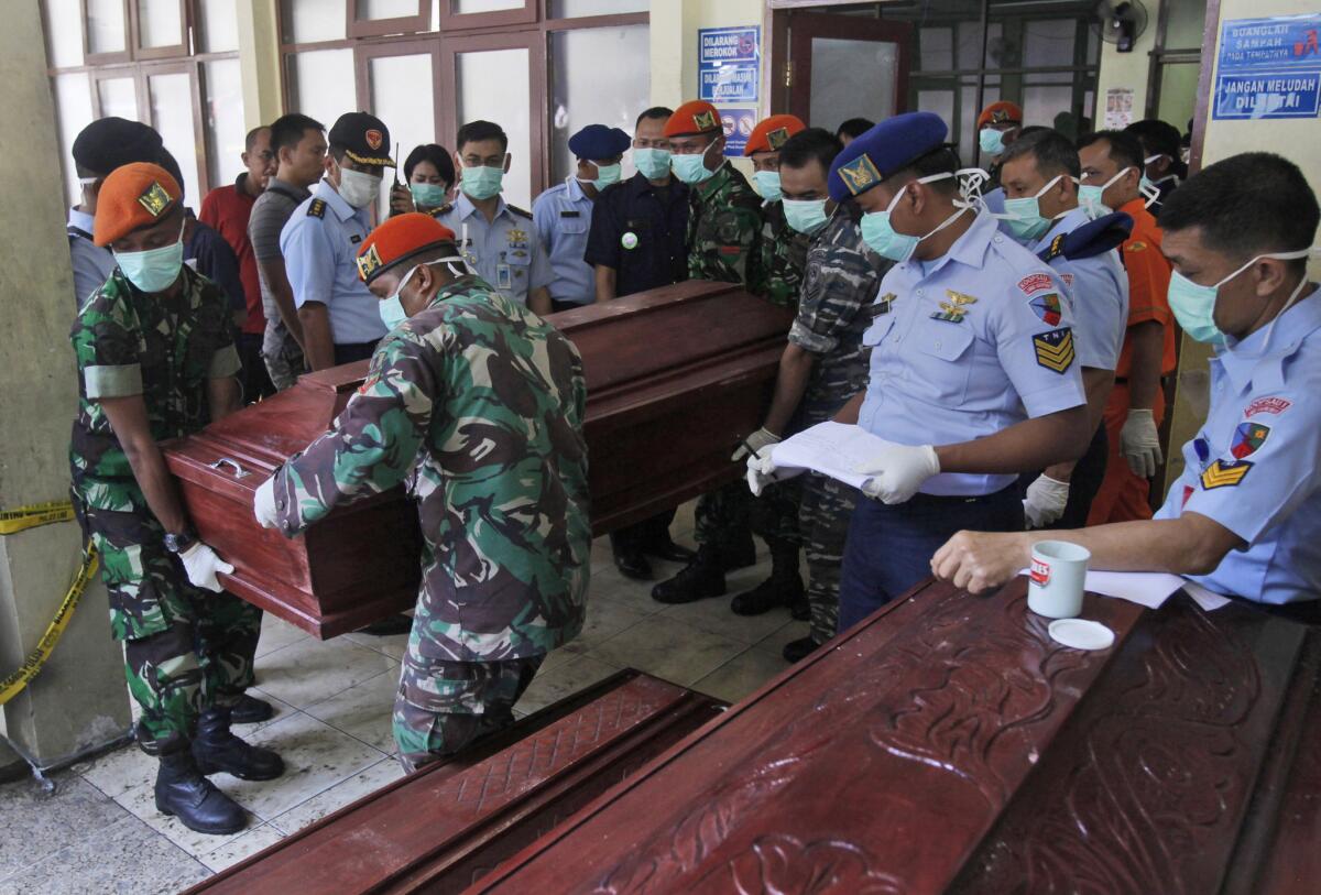 Indonesian air force personnel carry the body of a victim of a military plane crash in Medan.