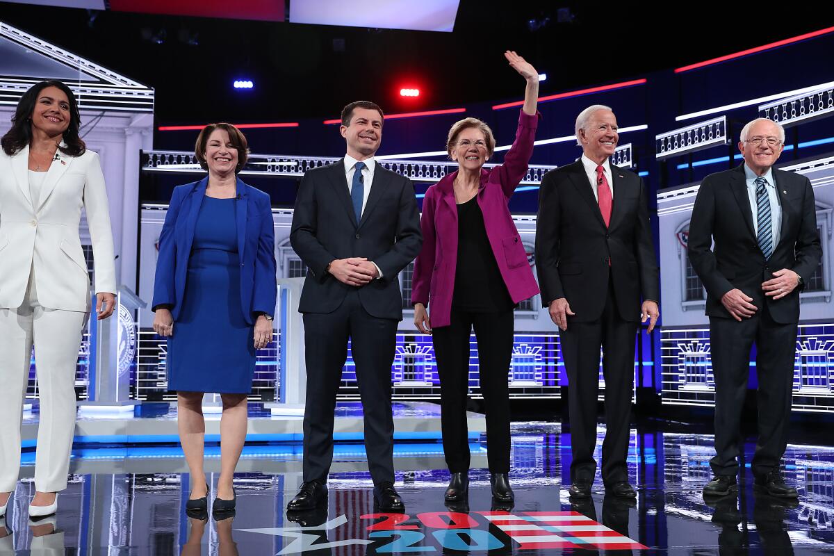 Democratic presidential candidates, from left, Tulsi Gabbard, Amy Klobuchar, Pete Buttigieg, Elizabeth Warren, Joe Biden and Bernie Sanders, arrive on stage before the start of their debate in Atlanta on Wednesday.