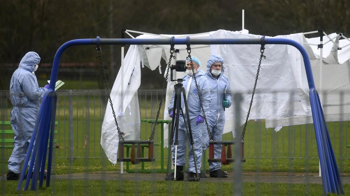 Police forensic officers investigate the scene in east London where a 17-year-old girl was stabbed to death Friday night.