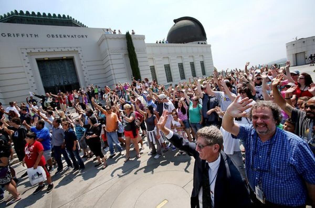 Hundreds of people gather at Griffith Observatory to wave at NASA's Cassini spacecraft, which is orbiting Saturn. The spacecraft's onboard cameras snapped a portrait of Earth on Friday, capturing our planet in space as a pinprick of light just to one side of Saturn's spectacular rings.