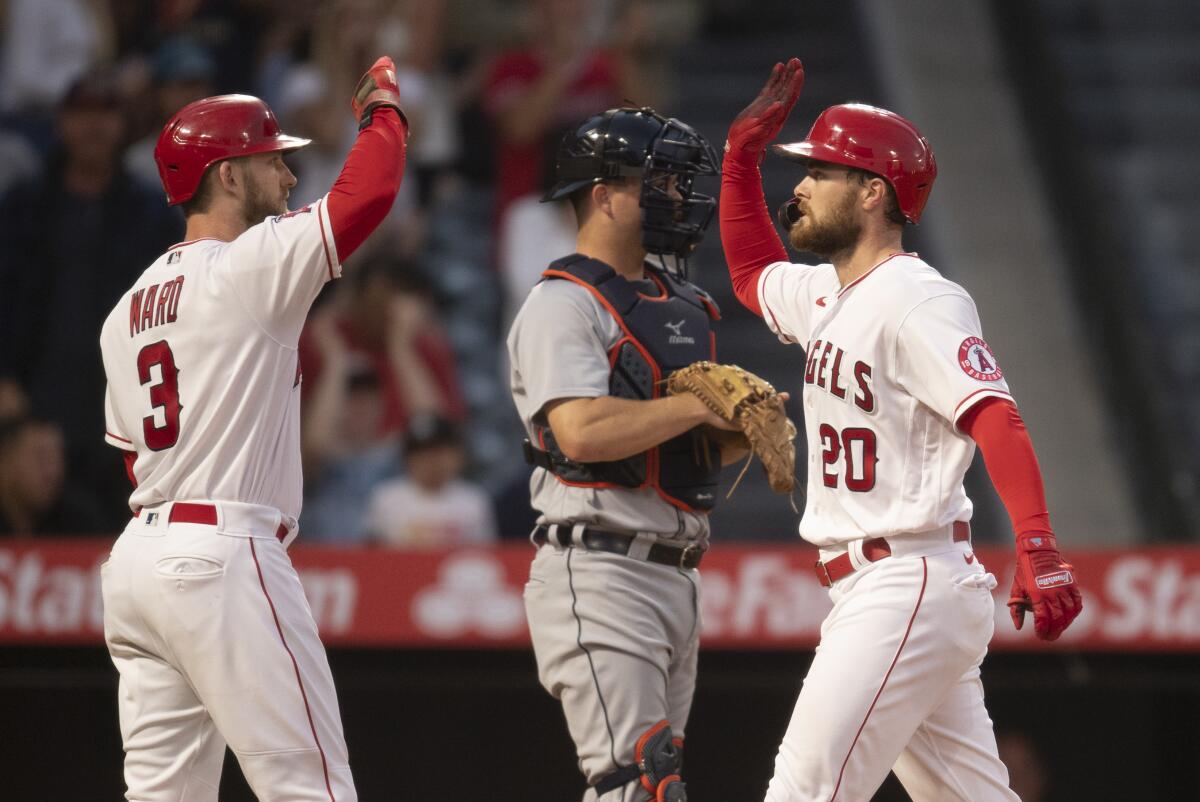 Jared Walsh and Taylor Ward celebrate the Angels' 8-3 win over the Detroit Tigers on Saturday.