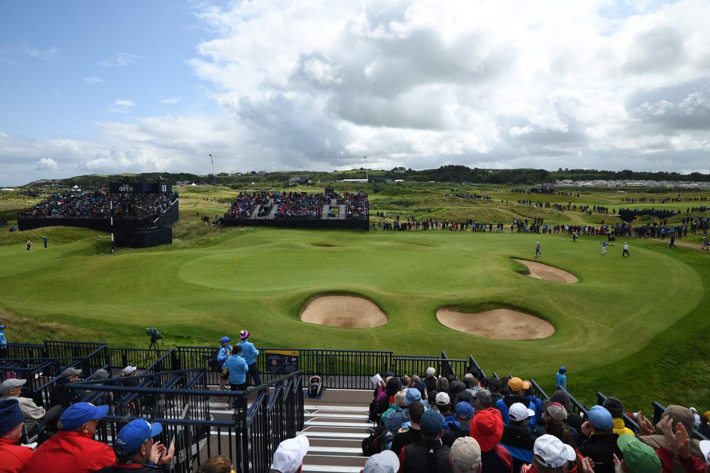 Golfers arrive on the 13th green during the first round of the 148th Open Championship at Royal Portrush Golf Club in Northern Ireland.