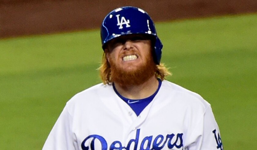 Dodgers third baseman Justin Turner grimaces after he is hit on the hand by a pitch in the fourth inning against the Giants.