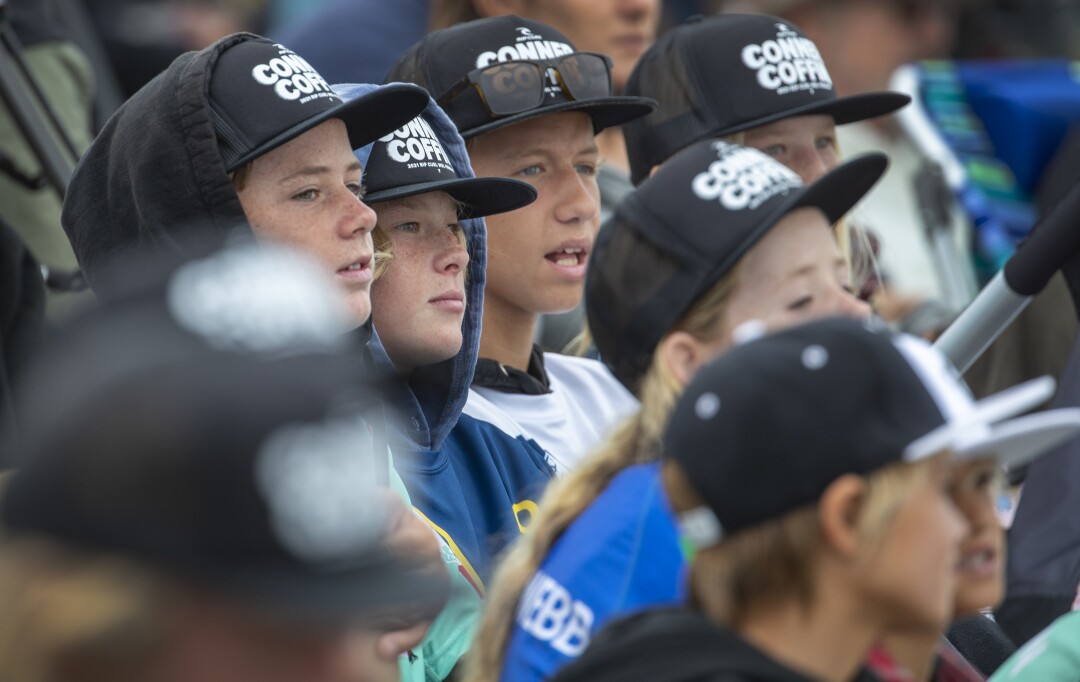 All wearing Conner Coffin hats, young fans watch their favorite surfer, Conner Coffin compete against Morgan Cibilic