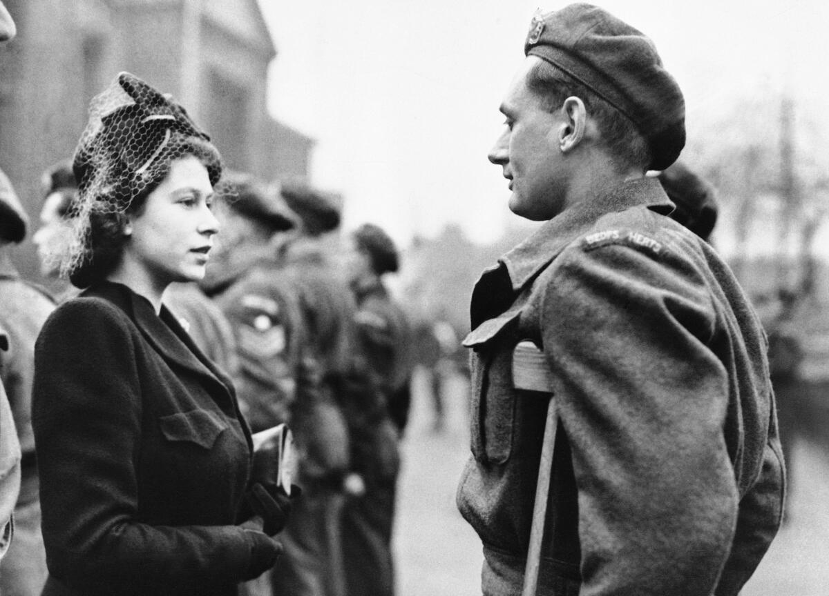 FILE - Princess Elizabeth of England talks to Private Rupert John Worth during a visit to Bedford, England on Feb. 14, 1946. (AP Photo, File)