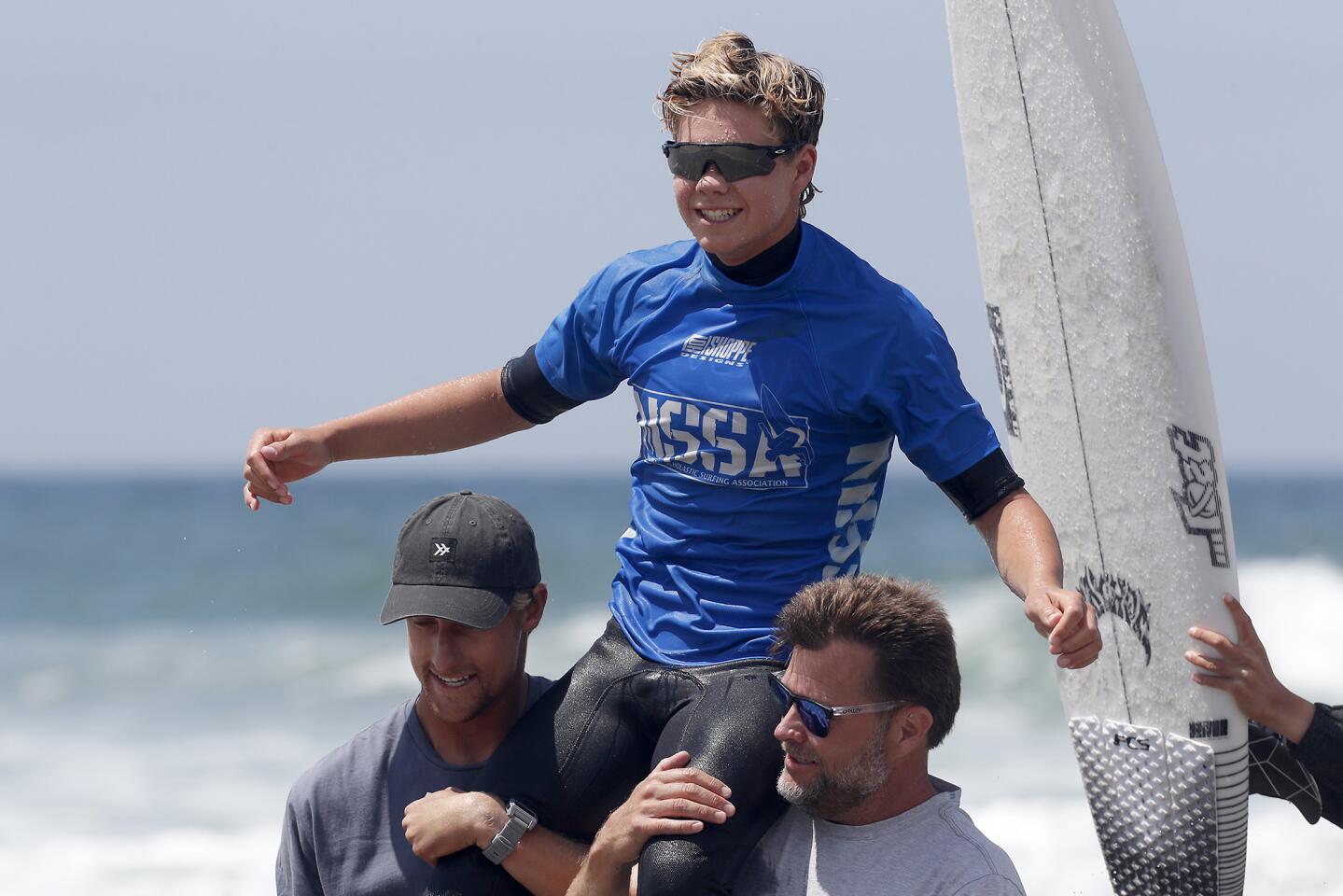 Taj Lindblad of San Clemente celebrates winning the open men's title at the National Scholastic Surfing Assn. National Championships in Huntington Beach on Wednesday.