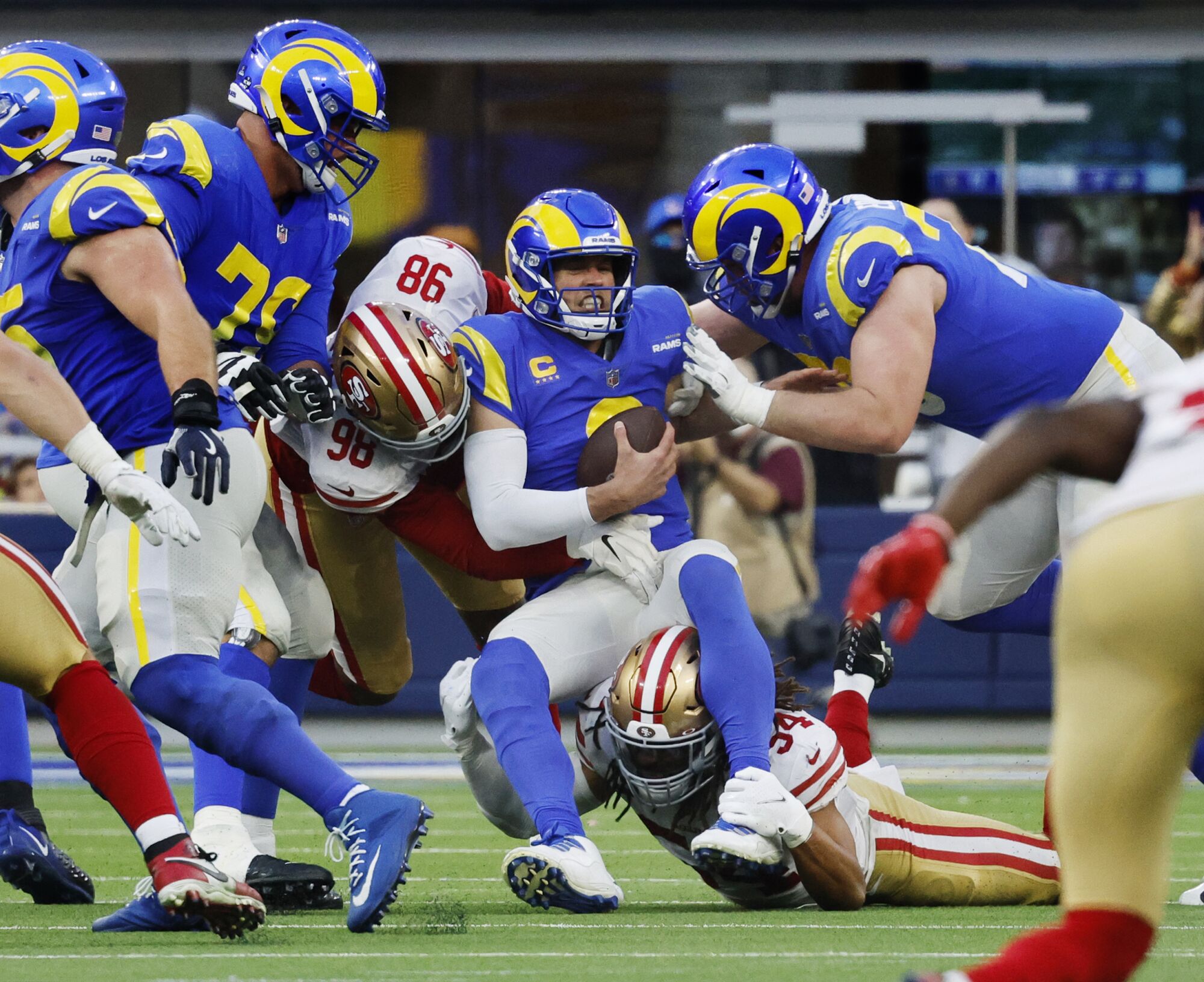 Rams quarterback Matthew Stafford is sacked by 49ers defensive end Arden Key (98) and middle linebacker Fred Warner 