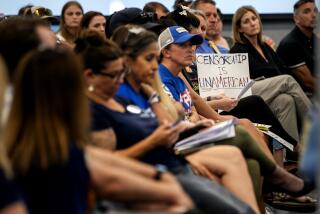 TEMECULA, CA - JULY 18, 2023: An audience member hold sup a sign that says "Censorship is UnAmerican" during a school board meeting on July 18, 2023 in Temecula, California. The conservative majority on the school board is at the center of a debate with Gov. Gavin Newsom who has threatened to fine the board over $1 million because of their resistance to include a lesson involving Harvey Milk.(Gina Ferazzi / Los Angeles Times)