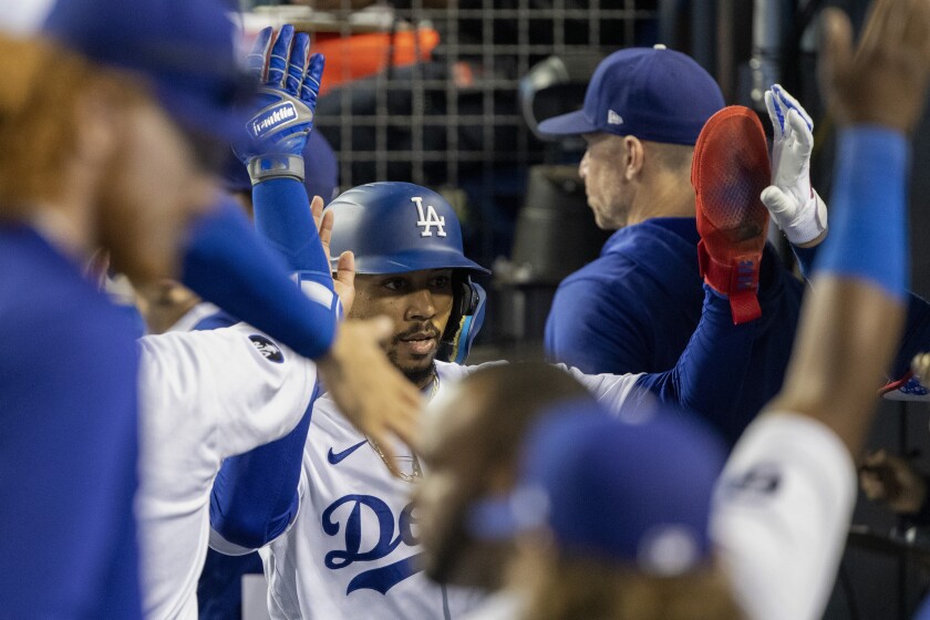 The Dodgers' Mookie Betts is congratulated in the dugout after he scored the go-ahead run Aug. 19, 2022.