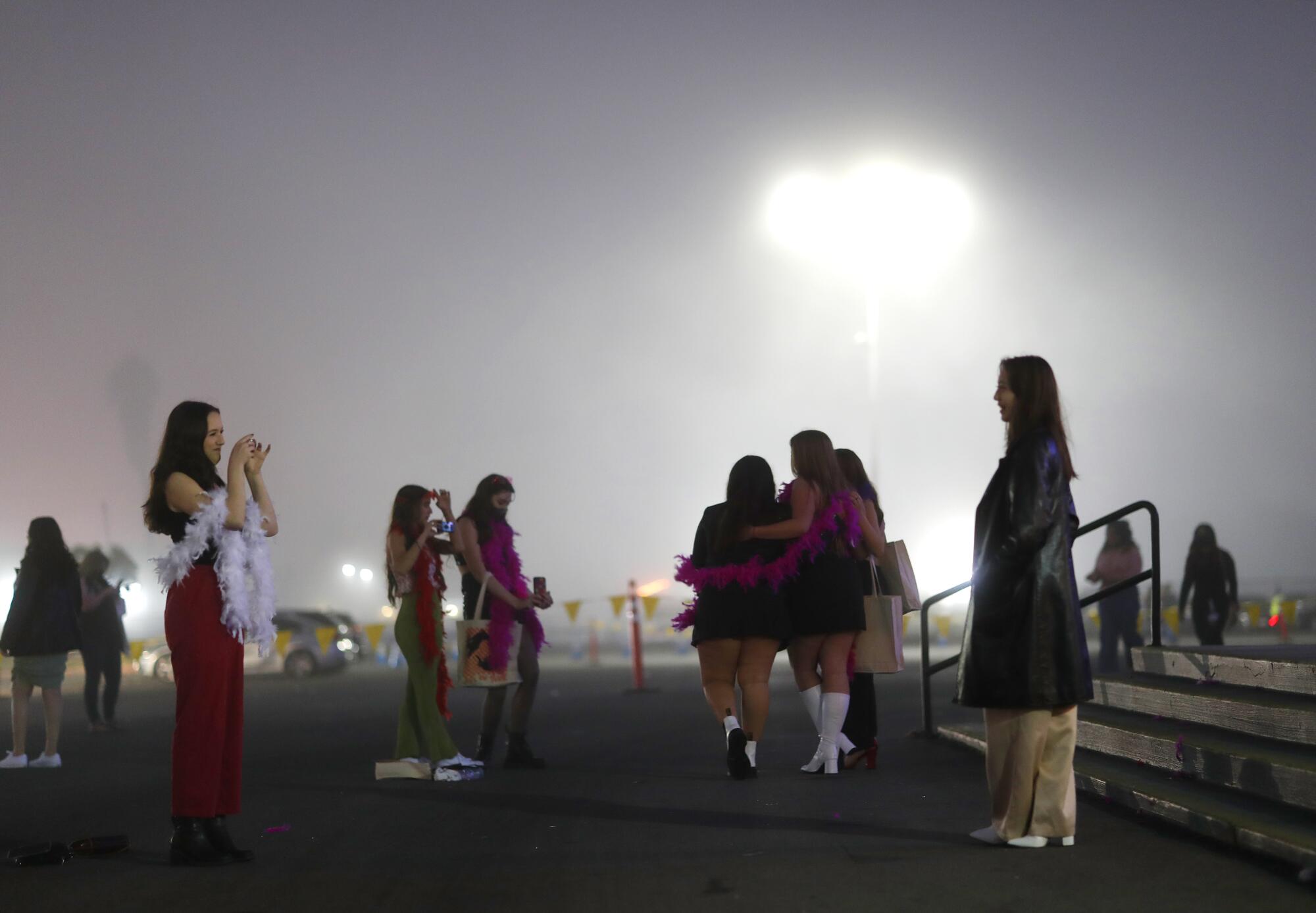 Fans take photos outside Pechanga Arena on a foggy night before the concert.