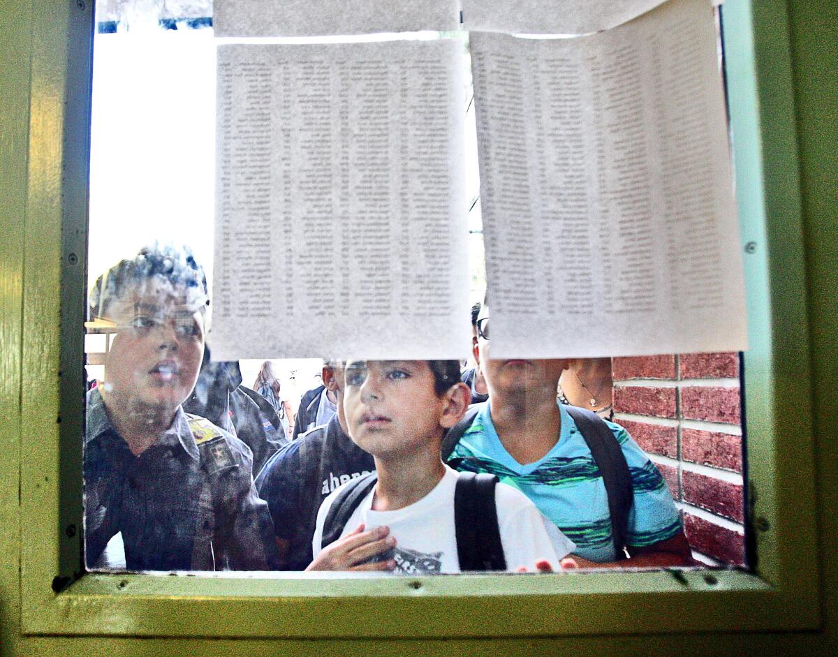 Students looks at room assignments on a door window on the first day of school at John Muir Middle School in Burbank on Monday, Aug. 17, 2015. Burbank school officials project that the 2016-17 academic year will begin with 14,884 students.