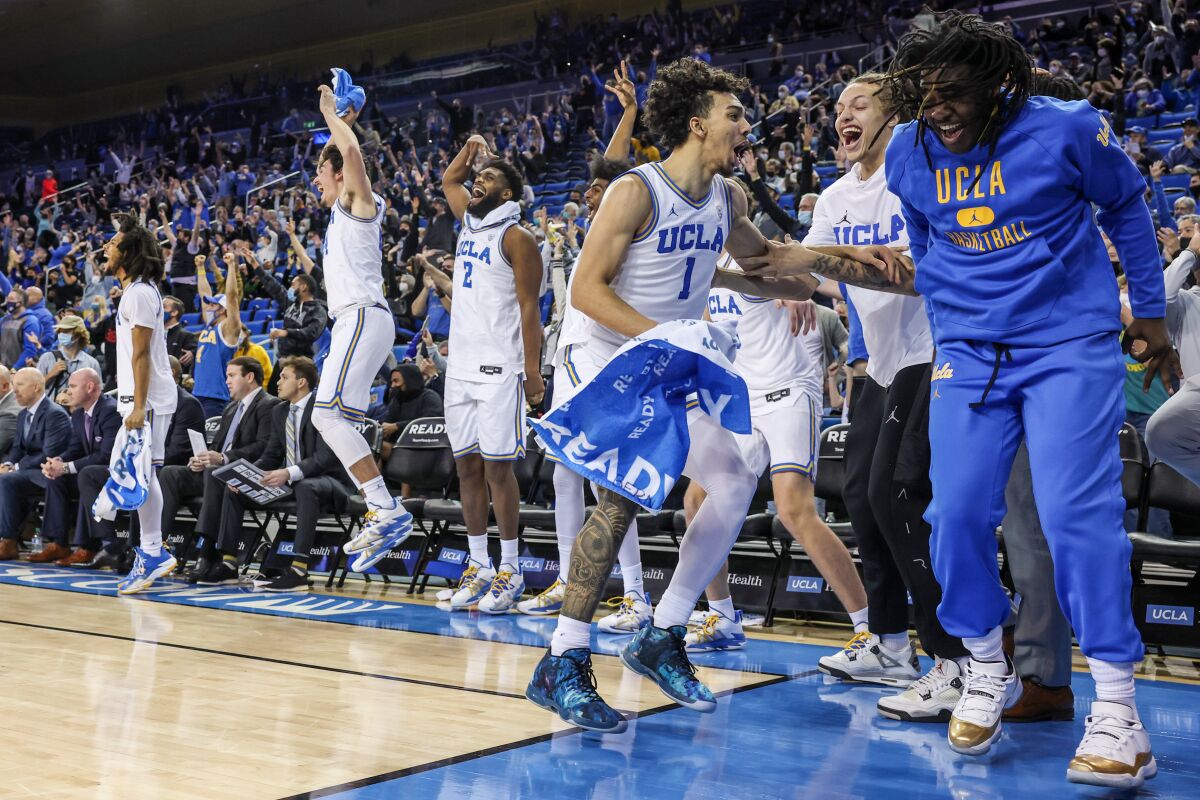 The UCLA bench erupts in joy after reserve UCLA Bruins guard Russell Stong (43) makes a long shot late in the game