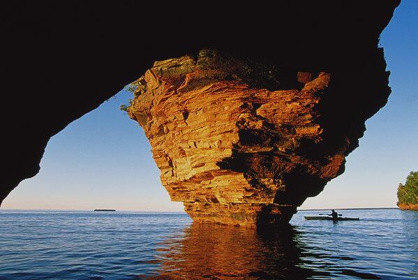 A kayaker passes a cave on Lake Superior in Wisconsin.