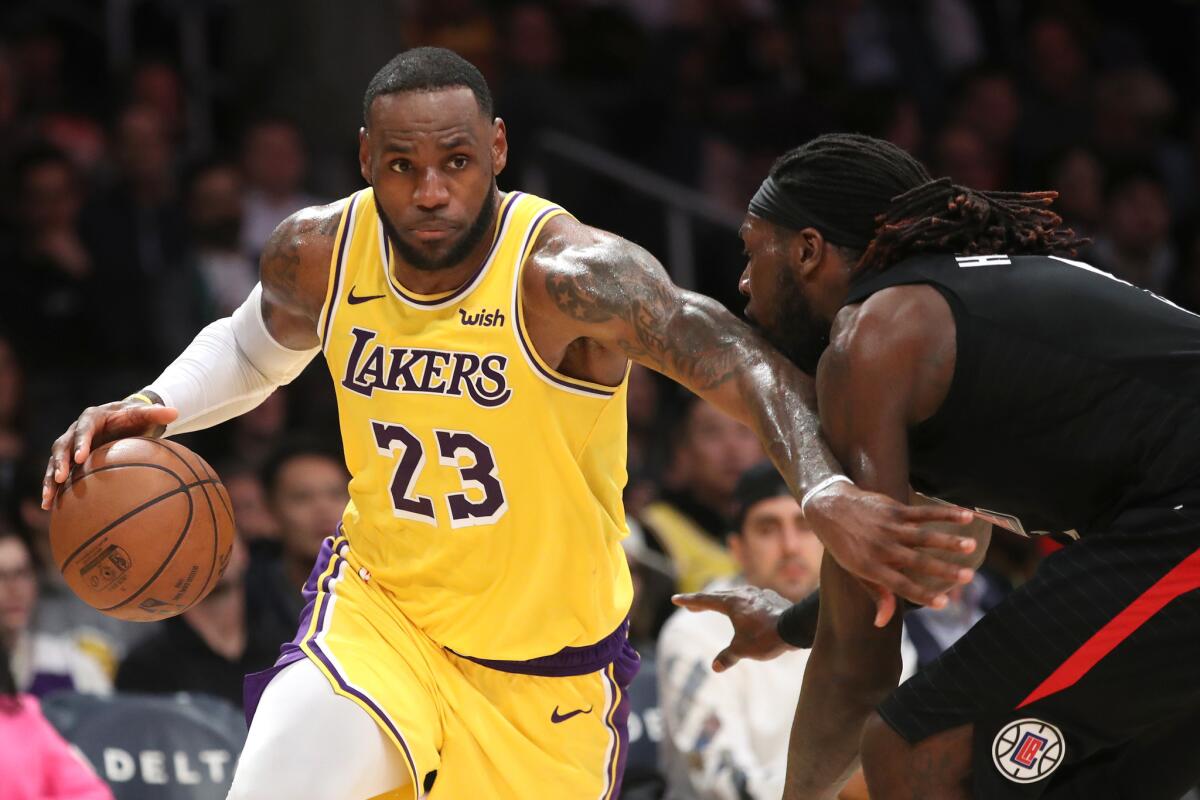 Lakers' LeBron James dribbles past Clippers' Montrezl Harrell at Staples Center.