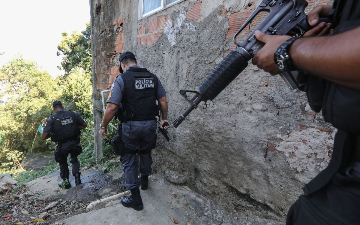 Police officers patrol a favela, or slum, in Rio de Janeiro. In some favelas, drug-trafficking gangs have made a comeback.
