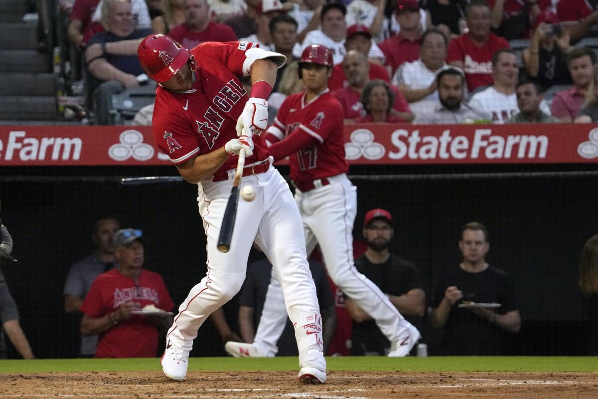 The Angels' Mike Trout grounds into a double play as Shohei Ohtani watches.