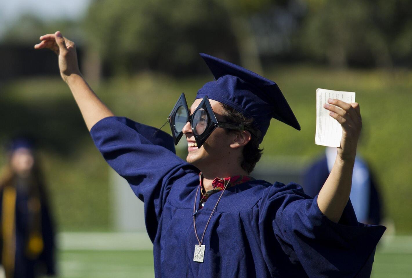 Spencer Swanson waves to the crowd during the 2016 commencement ceremony for Newport Harbor High School at Orange Coast College on Thursday.