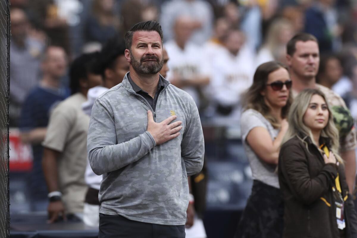 El gerente general de los Padres, Eric Graepner, es visto durante el himno nacional antes de un partido de béisbol contra los Marlins en mayo de 2022.