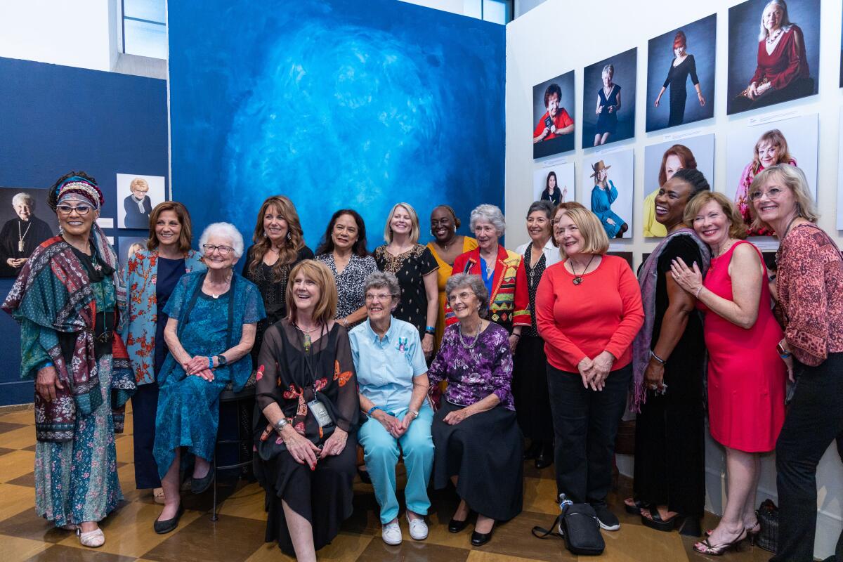 Women gather at the "Looking Back/Moving Forward: The Wisdom of Older Women" exhibition at Fullerton Museum.