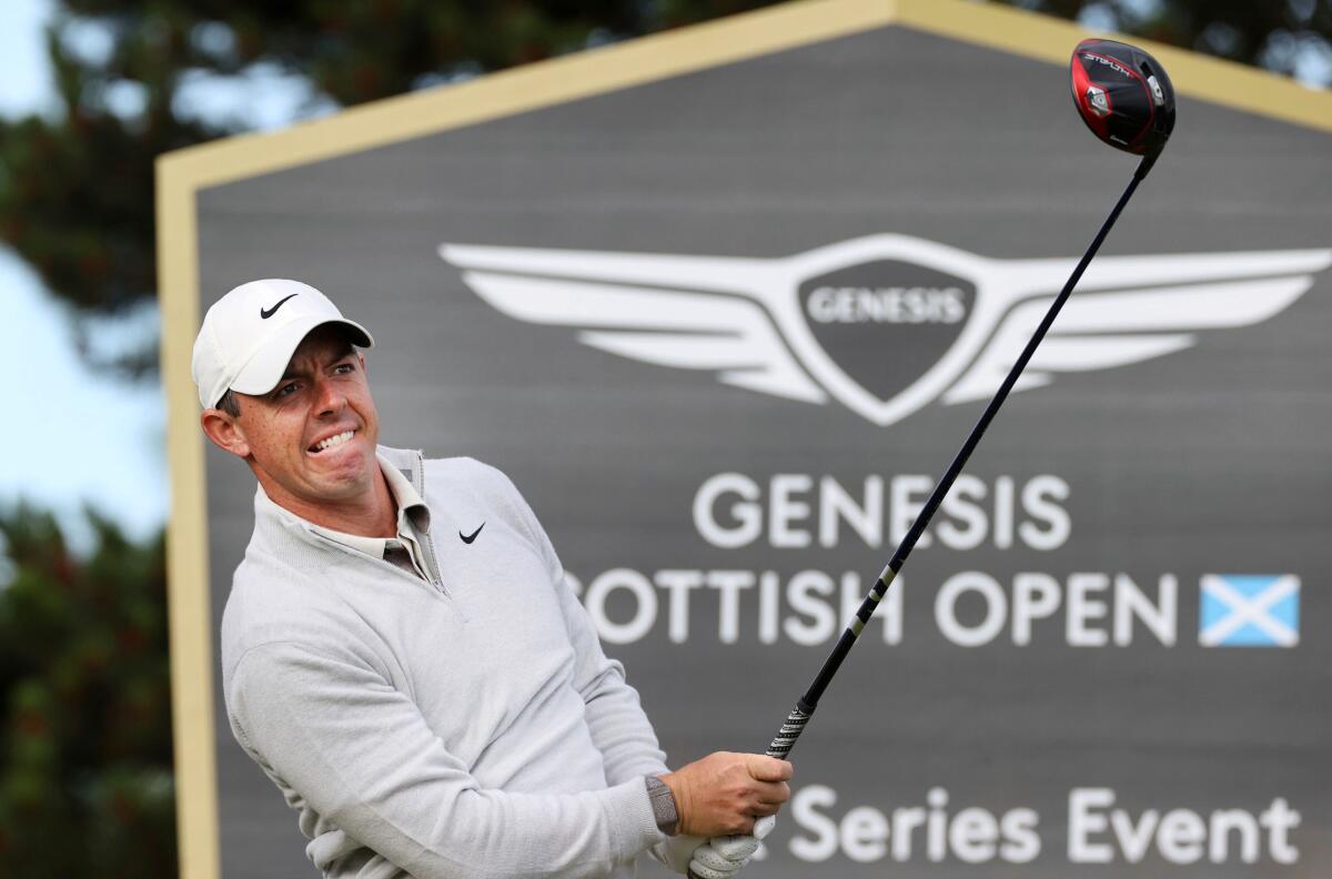 Rory McIlroy bites down on his lower lip as he tees off 
