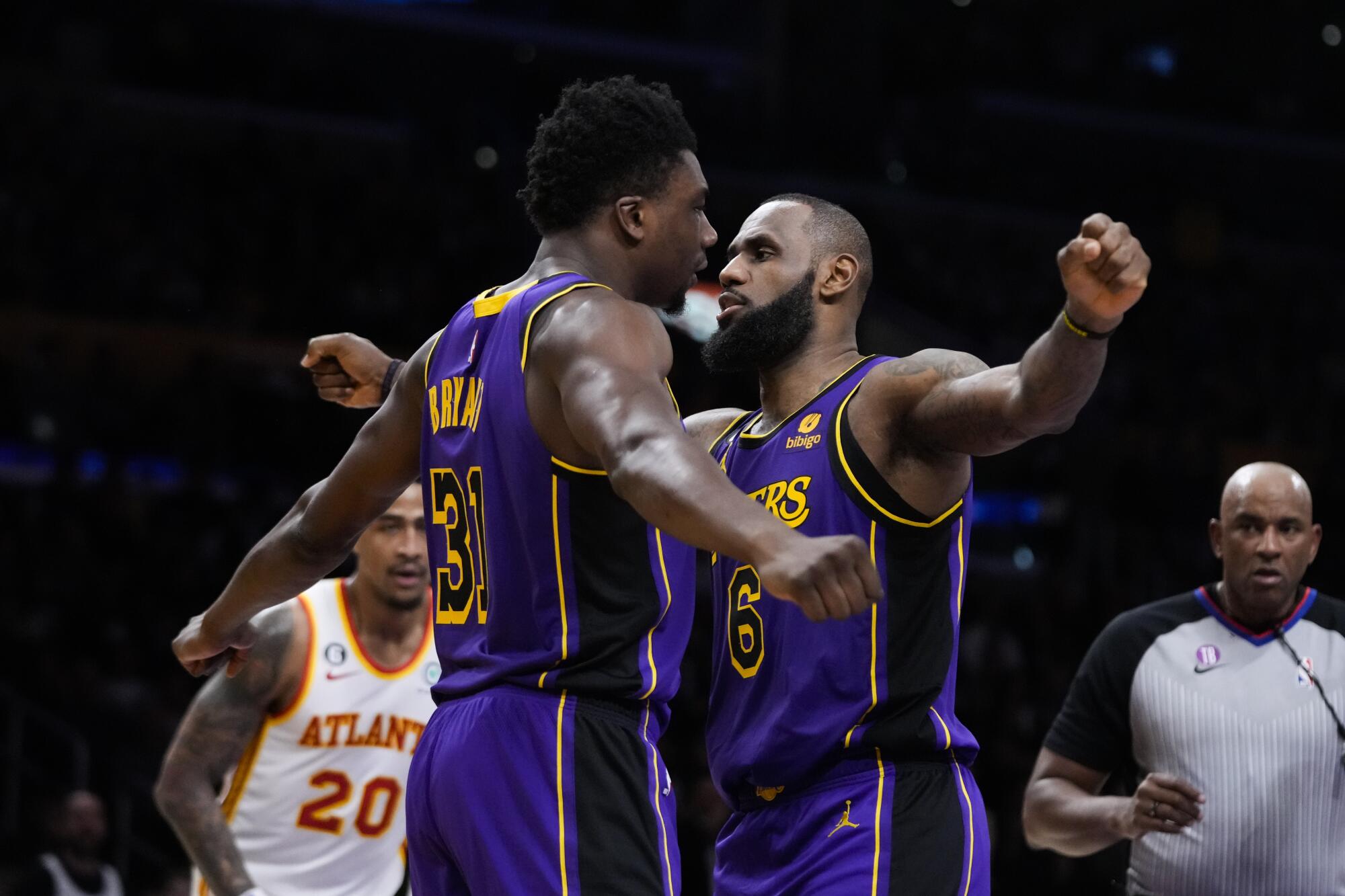 Lakers center Thomas Bryant (31) and forward LeBron James bump chests after Bryant scored a basket.