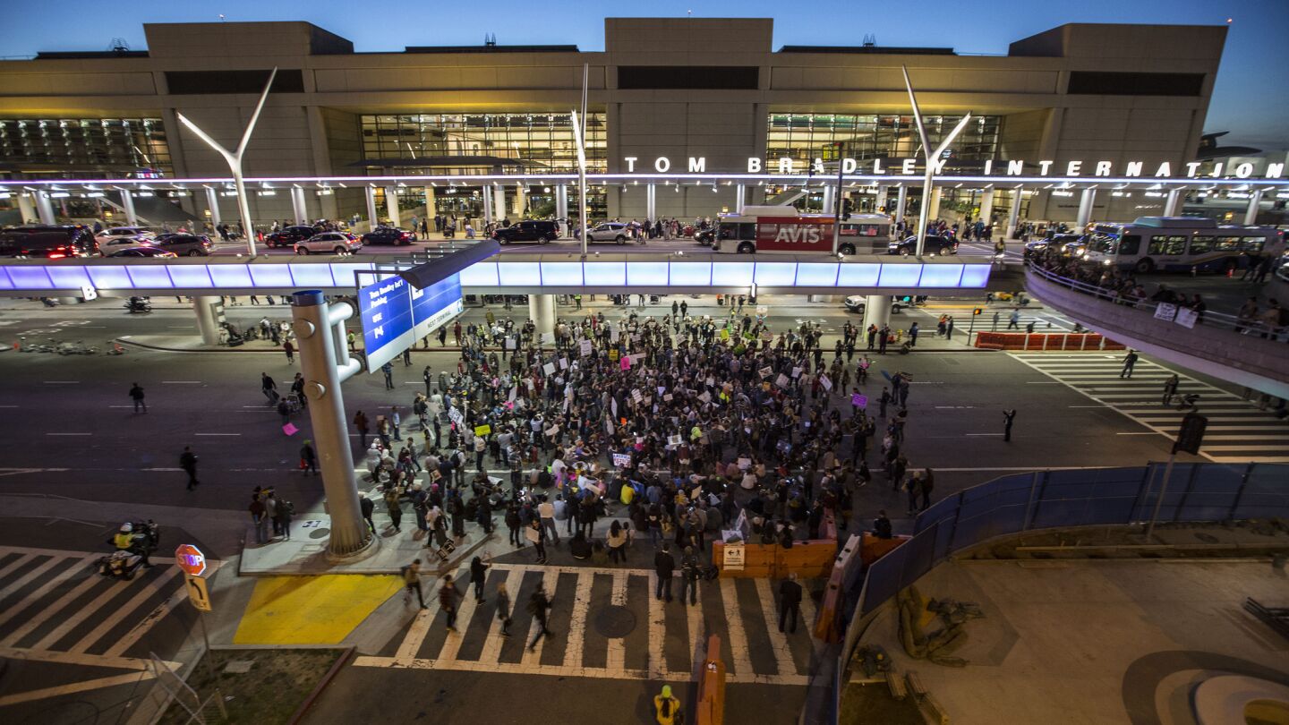 Hundreds sit in on the arrival level of LAX's Tom Bradley International Terminal, blocking traffic to protest President Trump's immigration order.