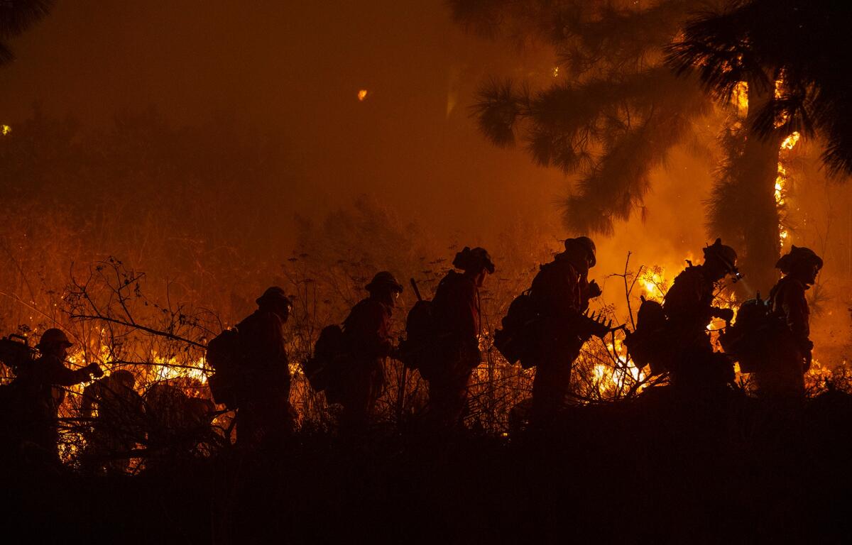 Firefighters head out for brush work in the Sepulveda Pass during the Getty fire.