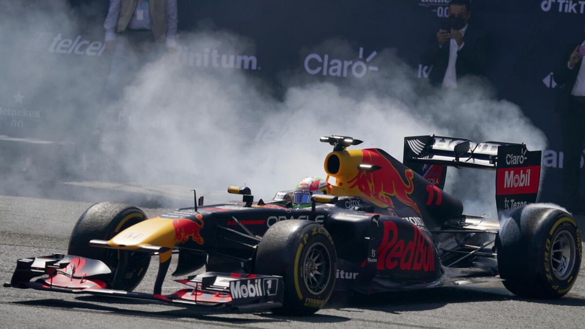 El piloto mexicano de Fórmula Uno Red Bull Sergio "Checo" Pérez hace girar sus neumáticos 