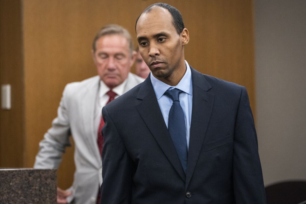 FILE - In this Friday, June 7, 2019 file photo, Former Minneapolis police officer Mohamed Noor walks to the podium to be sentenced at Hennepin County District Court in Minneapolis. Noor, who shot and killed a 911 caller minutes after she had reported a possible rape behind her home in 2017 is asking a judge to sentence him to 41 months on a manslaughter charge. Mohamed Noor is being re-sentenced after the Minnesota Supreme Court tossed out his third-degree murder conviction. (Leila Navidi/Star Tribune via AP, Pool, File)