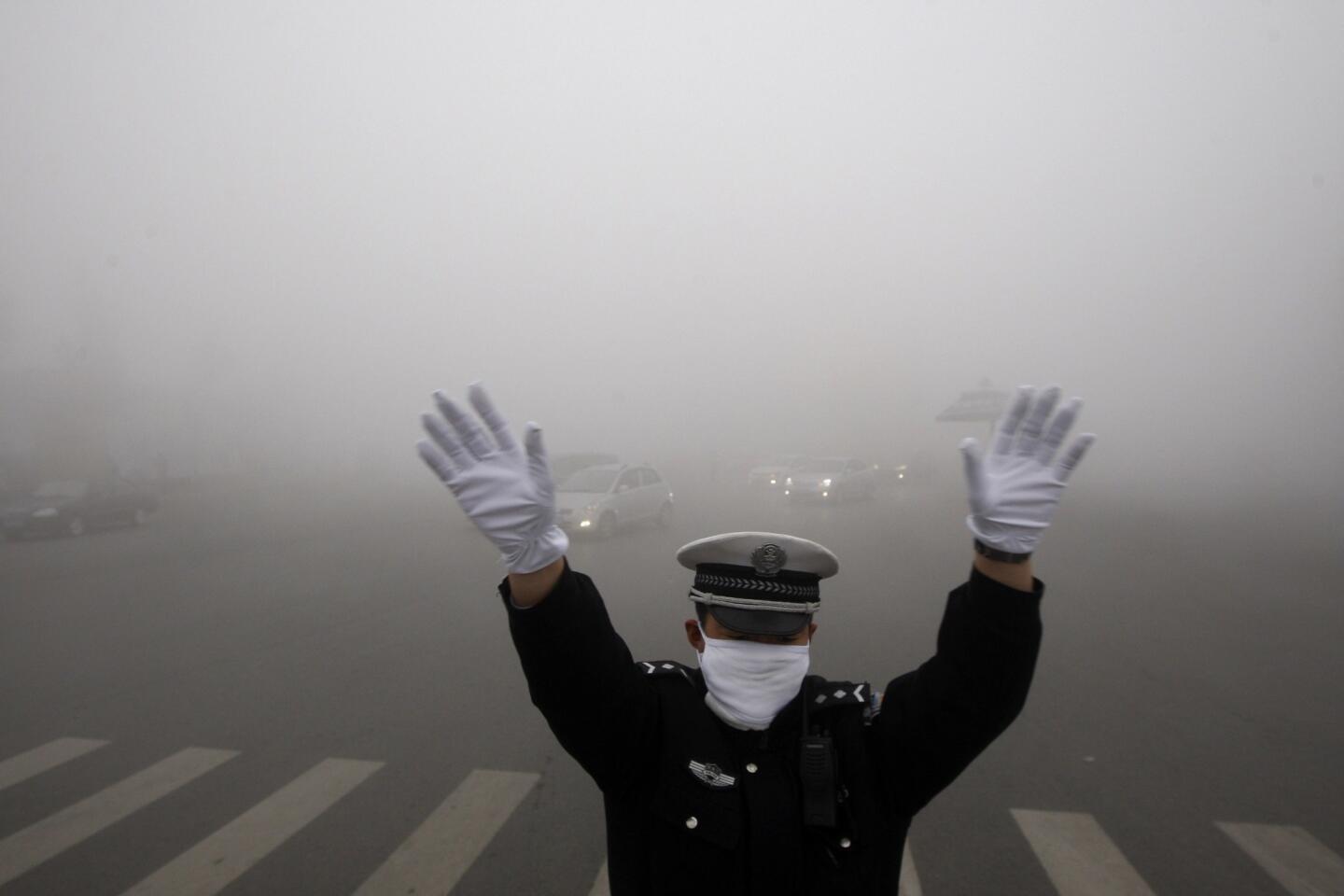 A policeman works on a pollution-shrouded street in Harbin, China.
