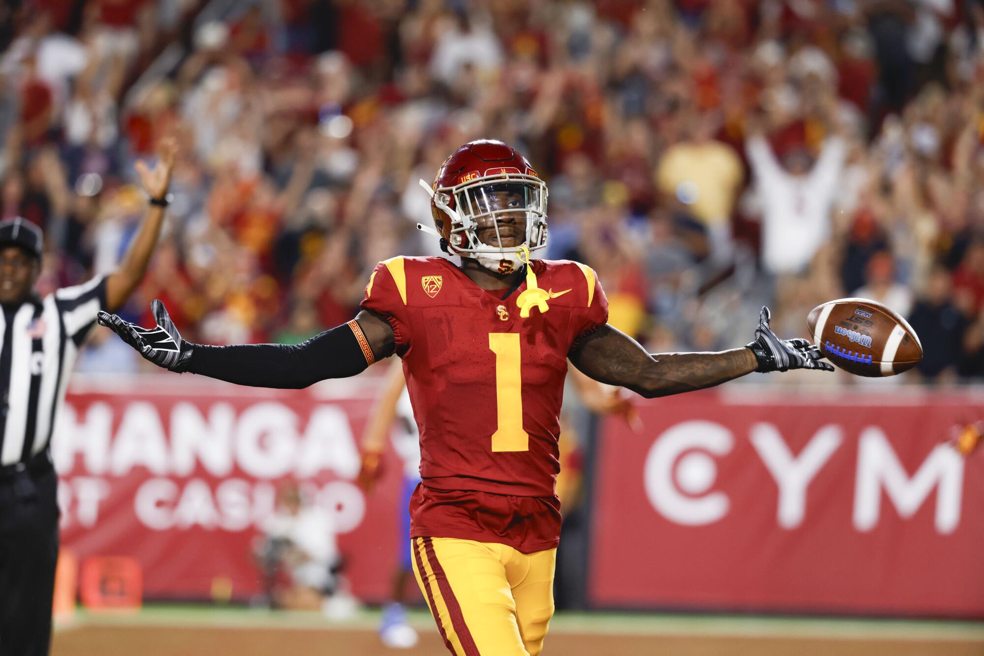 USC receiver Zachariah Branch extends his arms and celebrates after returning a kickoff for a touchdown 