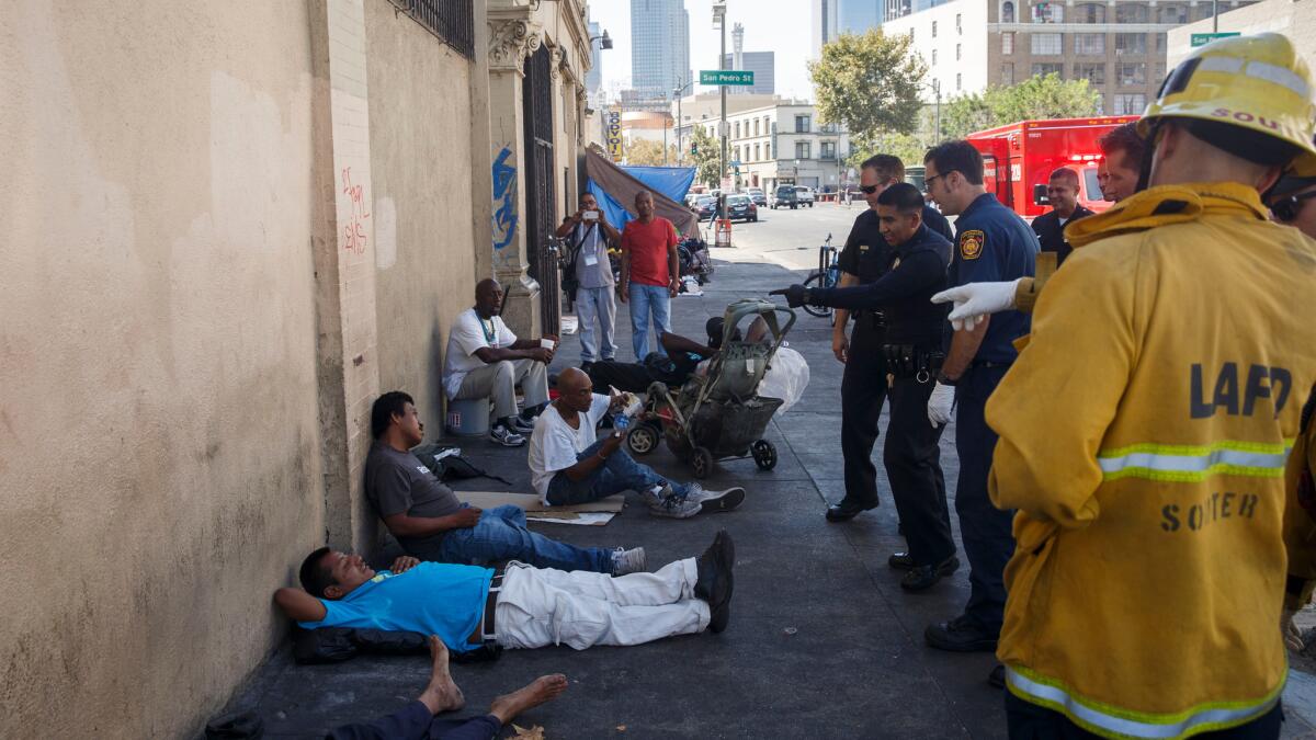 Los Angeles Fire Department paramedics and Los Angeles Police Department officers respond to multiple people who had fallen ill on Aug. 19 on skid row.