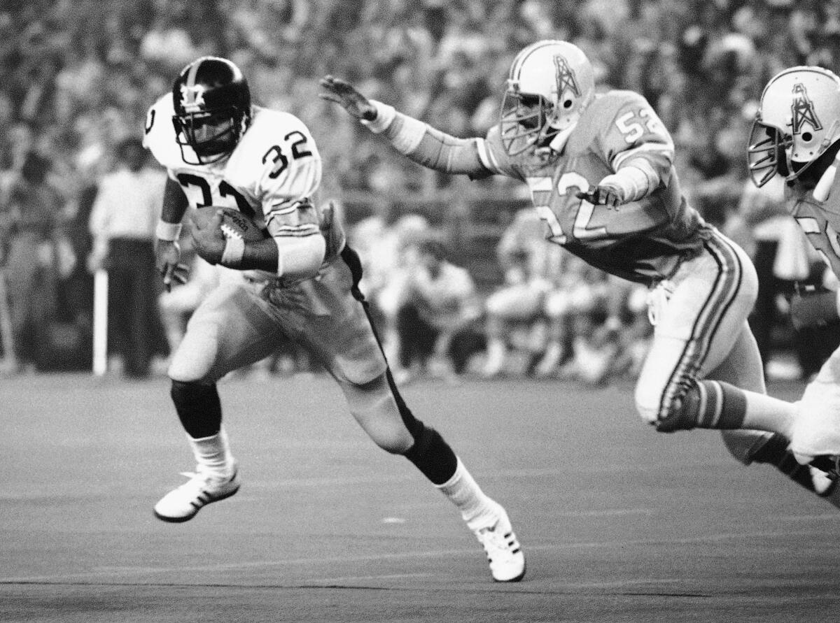 Franco Harris carries the ball for the Steelers.