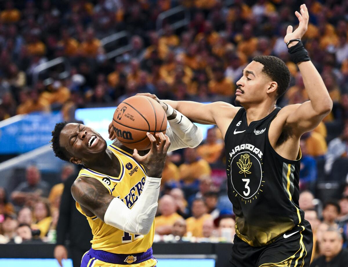 Golden State Warriors guard Jordan Poole, right, fouls Lakers guard Dennis Schroder during Game 1.