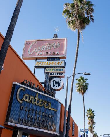 Canter's Deli is an orange building with several signs and palm trees