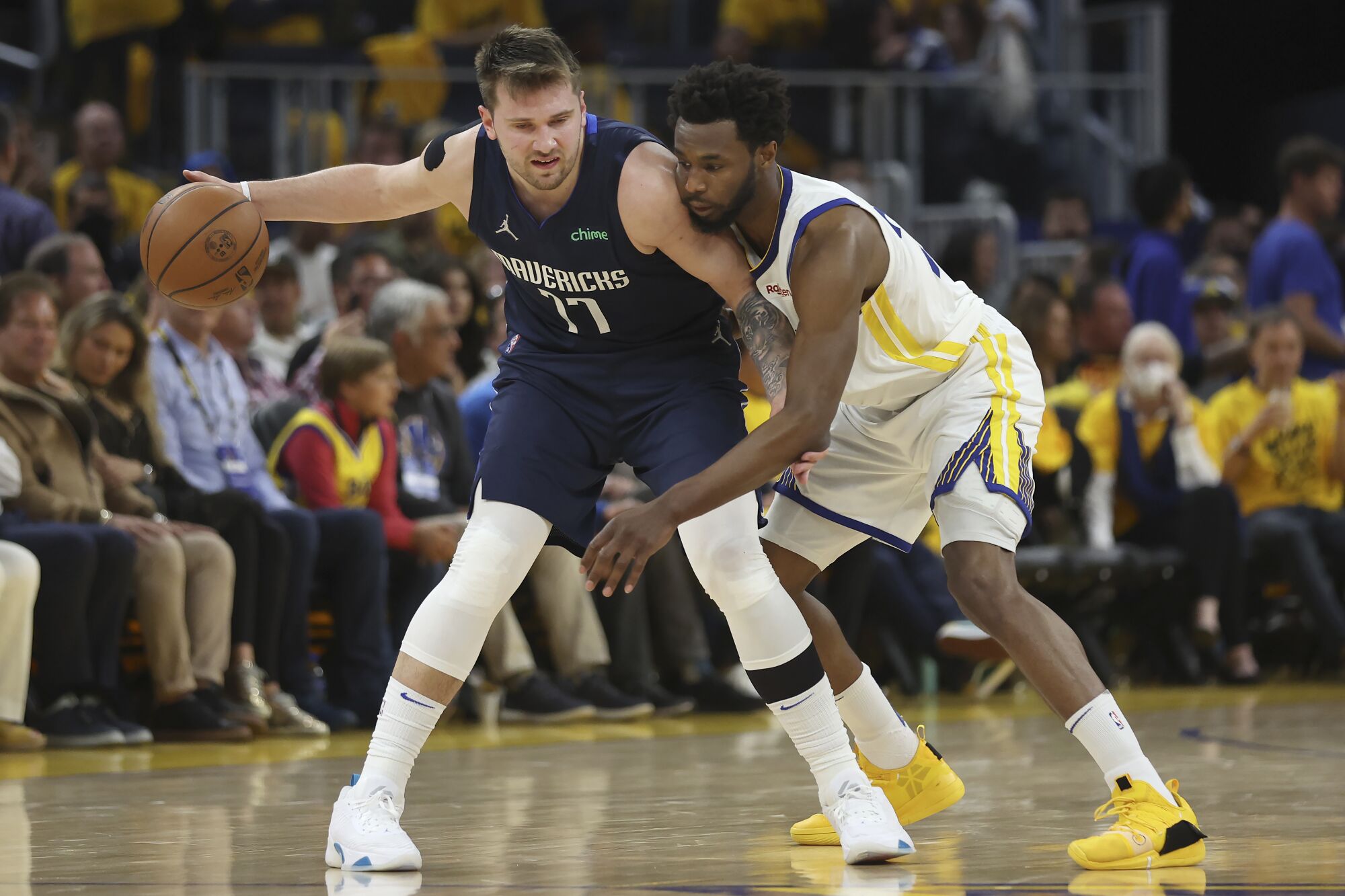 Warriors forward Andrew Wiggins plays tight defense against Mavericks guard Luka Doncic.