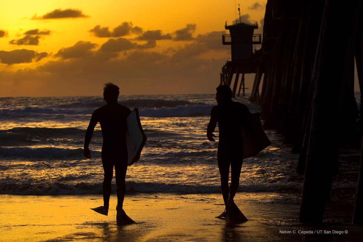 James Willmott and Anthony Zambrano head out to enjoy a sunset evening on their boogie boards at Imperial Beach.