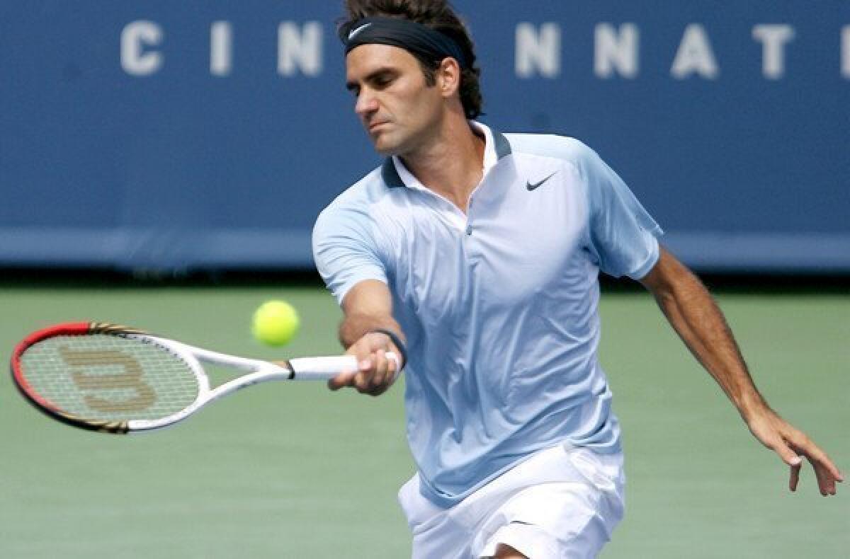 Roger Federer volleys a return against Tommy Haas during the third round of the Western & Southern Open in Mason, Ohio.