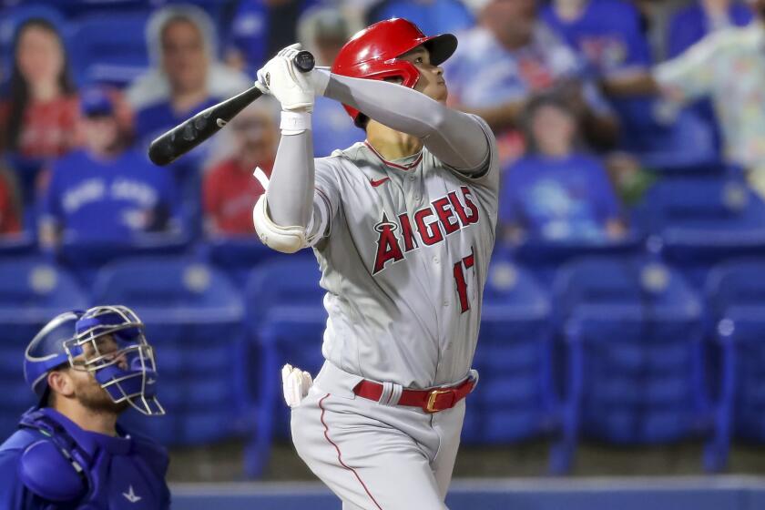 The Angels' Shohei Ohtani watches his solo home run as Blue Jays catcher Alejandro Kirk looks on April 9, 2021.