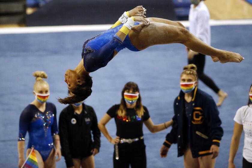 UCLA gymnast Margzetta Frazier dismounts from the uneven bars, scoring a 9.9 during a 2021 meet.