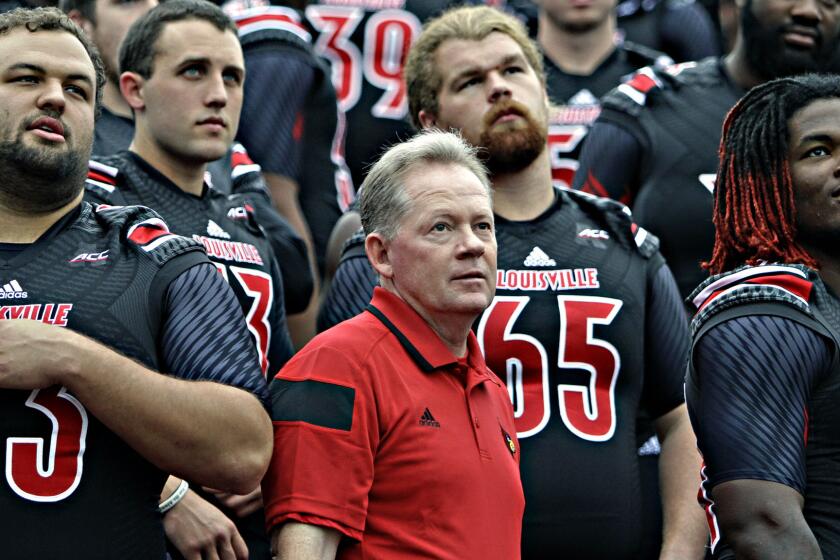 Louisville Coach Bobby Petrino looks on with his players during the team's picture day on Aug. 9. Louisville is the latest team to join the Atlantic Coast Conference.