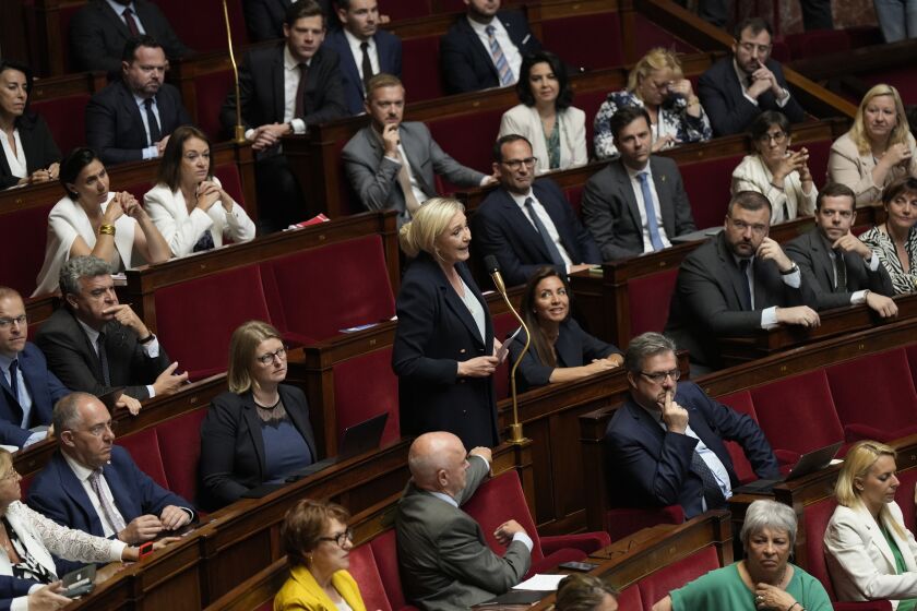 French far-right leader Marine Le Pen, center, speak at the National Assembly, Thursday, June 8, 2023 in Paris. French lawmakers are debating an opposition bill which aims to return the retirement age to 62 — it went up to 64 with Macron's unpopular reform. Legislators from centrist opposition group LIOT proposed the text, supported by leftists and the far-right. (AP Photo/Lewis Joly)