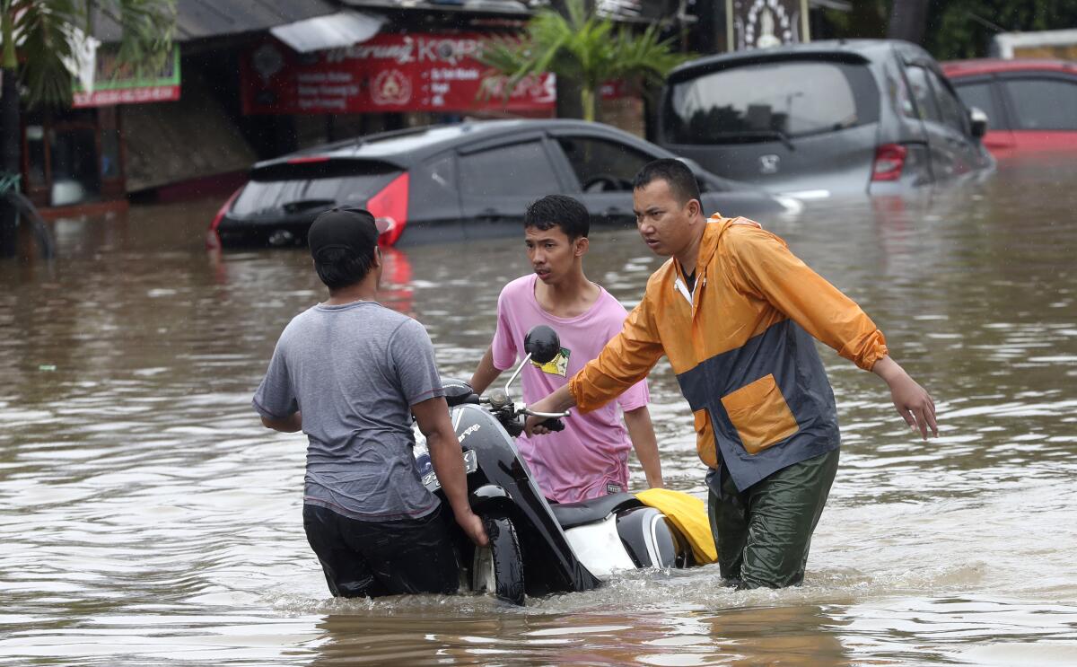 People wade through floodwaters on the outskirts of Jakarta, Indonesia, on Wednesday.