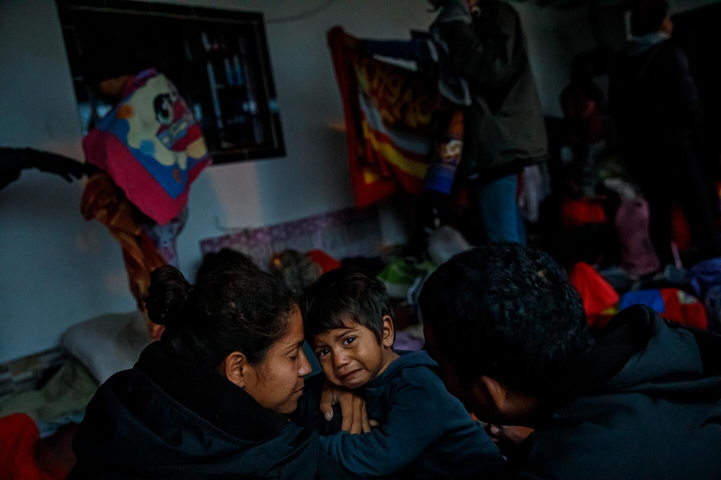 Rudimar Alvarez, 19, comforts son Jhorman Perez, 1, as her husband, Johan Perez, 25, looks on after spending a cold night sleeping outside a storefront in La Laguna, Colombia.